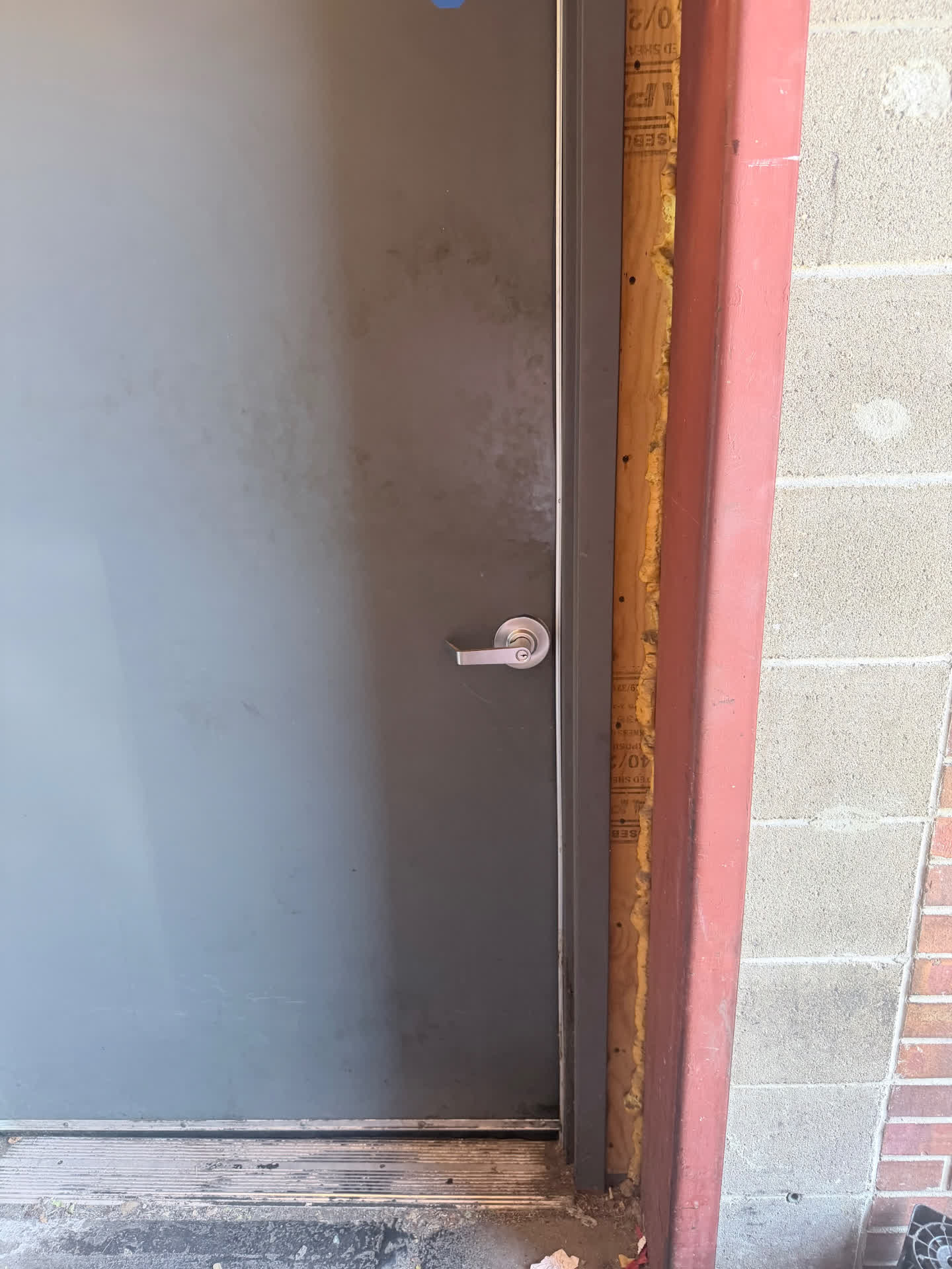 New commercial lever lock installed on a grey steel service door in Denver, Colorado