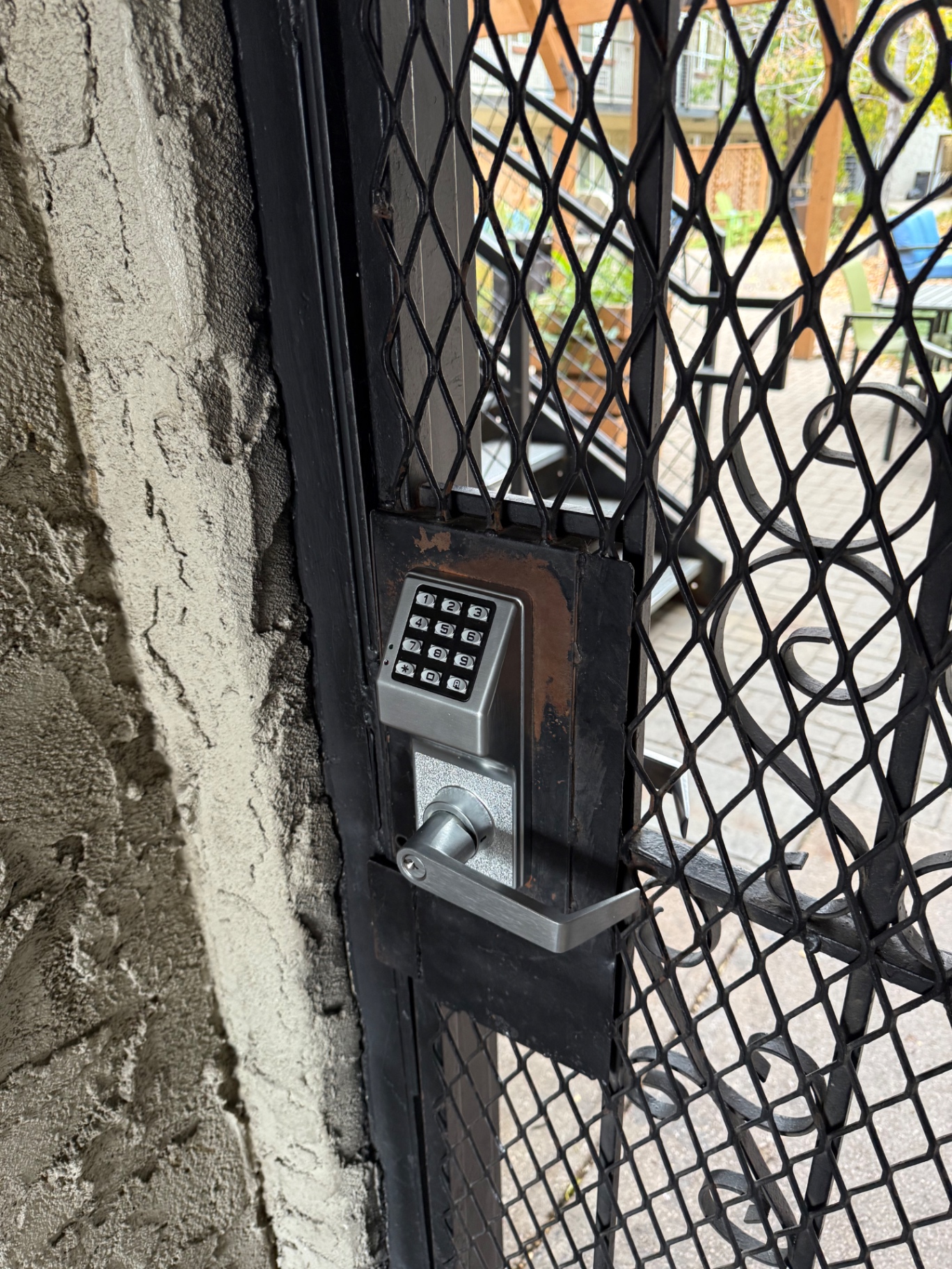 New commercial keypad lever lock installed on a black metal security gate in Denver, Colorado
