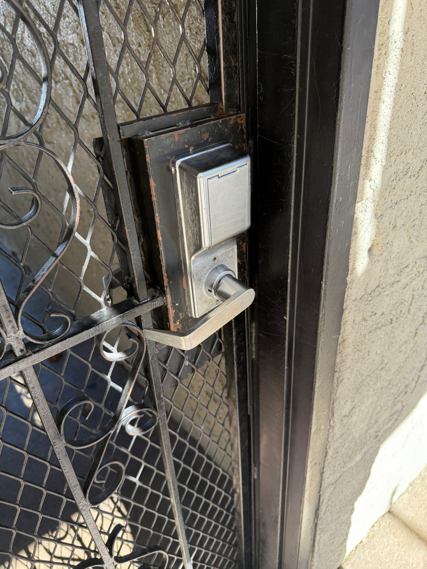 Original worn gate hardware before the commercial keypad lock installation in Denver, Colorado