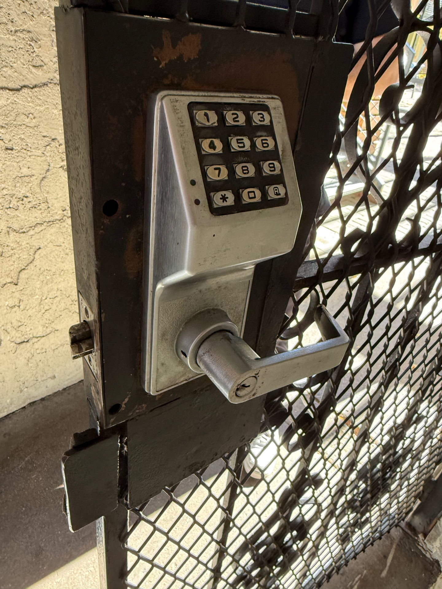 Close-up of the keyless entry keypad and lever on a commercial security gate in Denver, Colorado