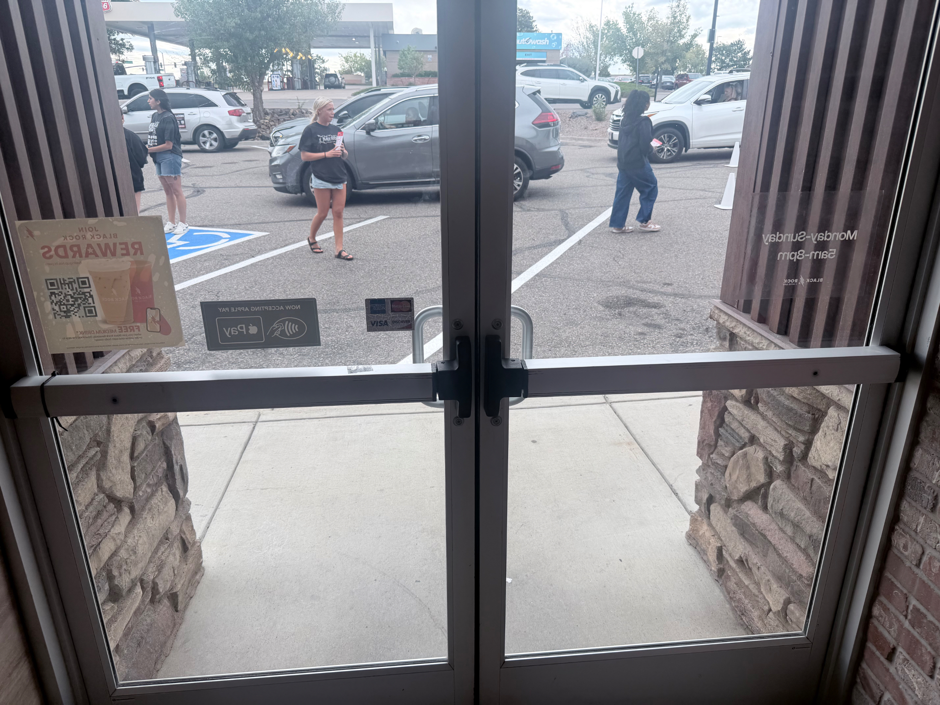 Commercial double glass doors with existing push bar hardware before replacement in Highlands Ranch Colorado