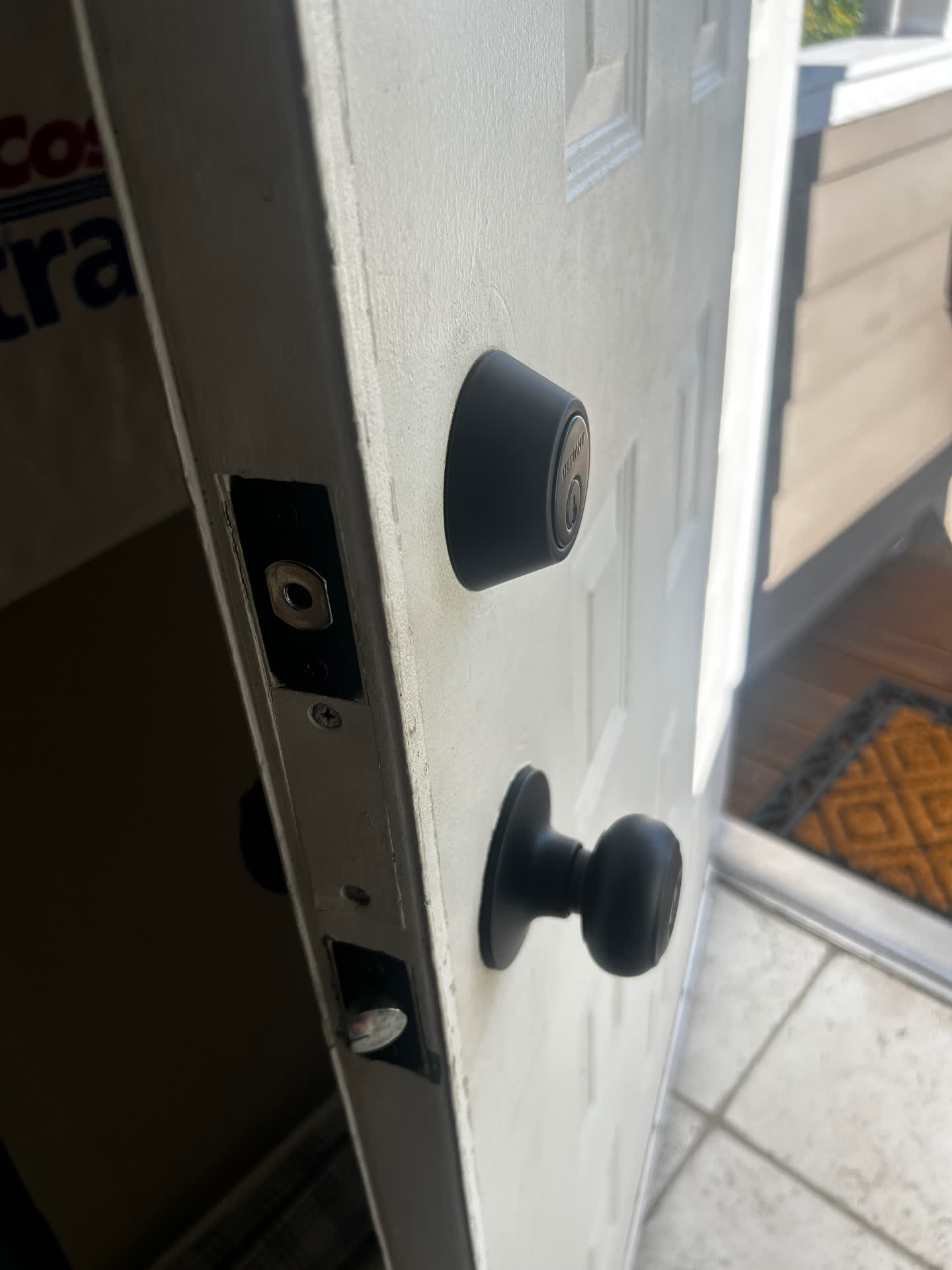Matte black deadbolt and knob set with aligned strike plates on a home entry door in Aurora, Colorado