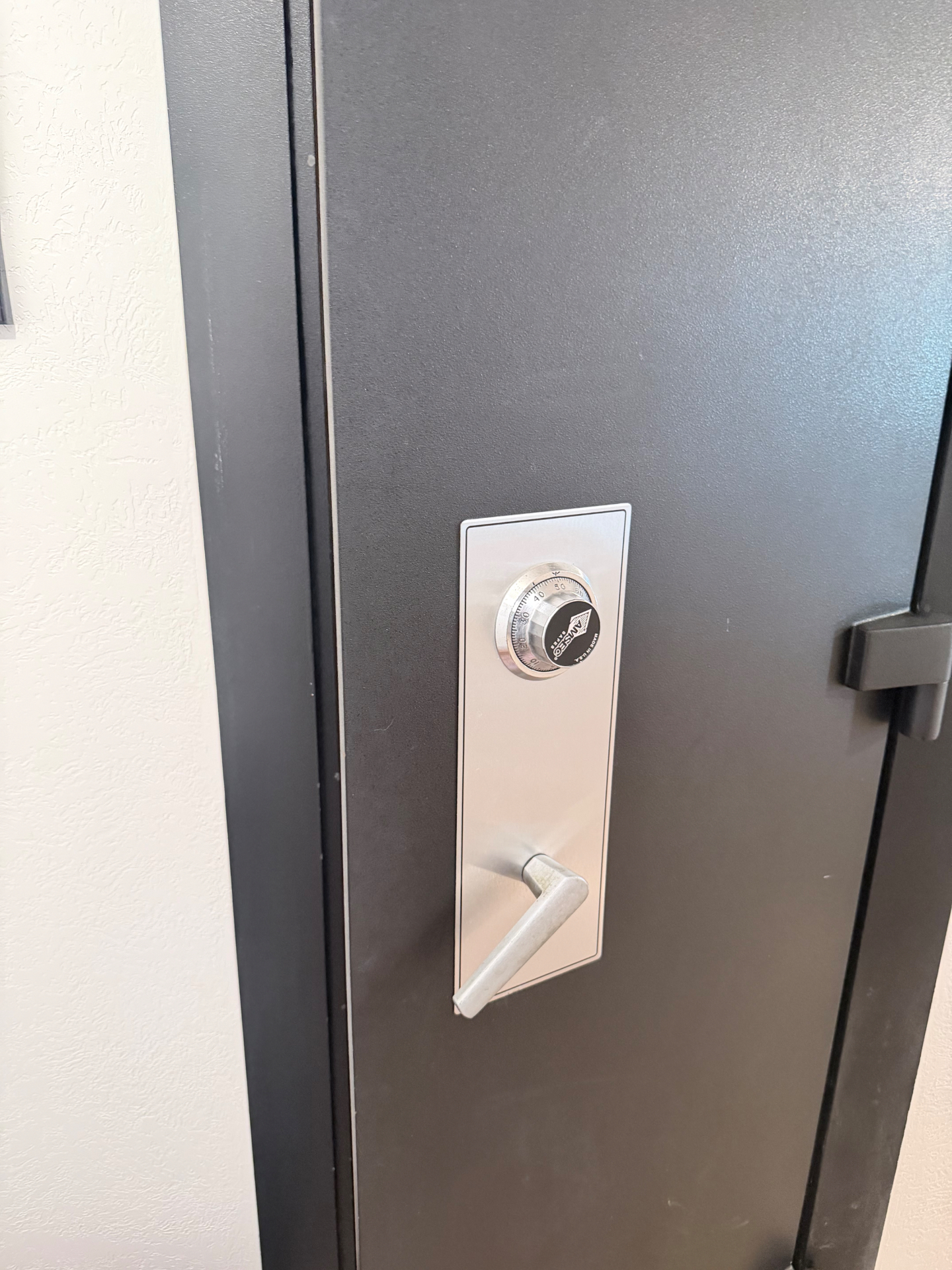 Original mechanical combination dial lock on a black residential gun safe before the lock change in Arvada, Colorado