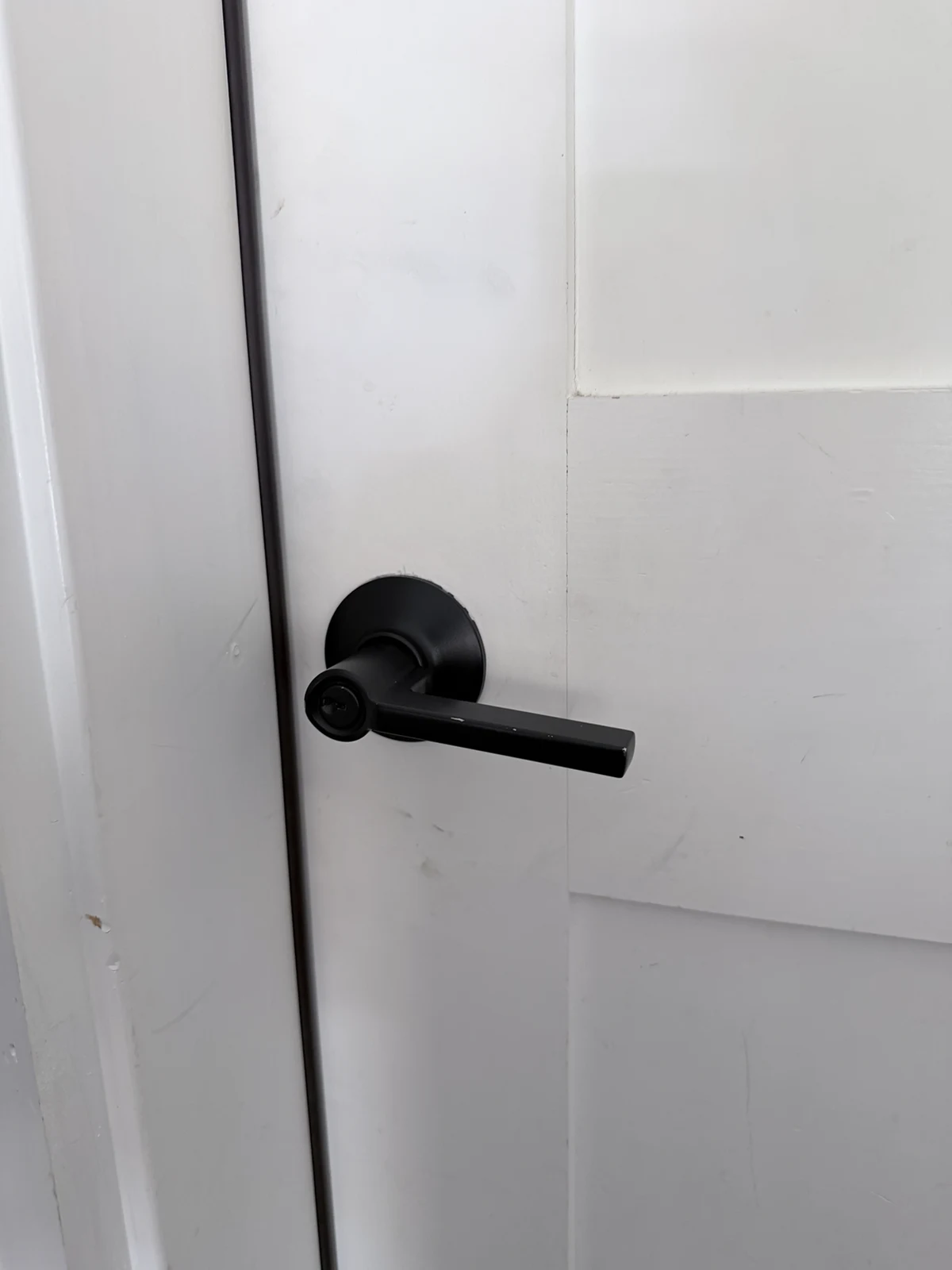 Matte black lever handle lock installed on a white interior door by Falcon Locksmith in Denver, Colorado.