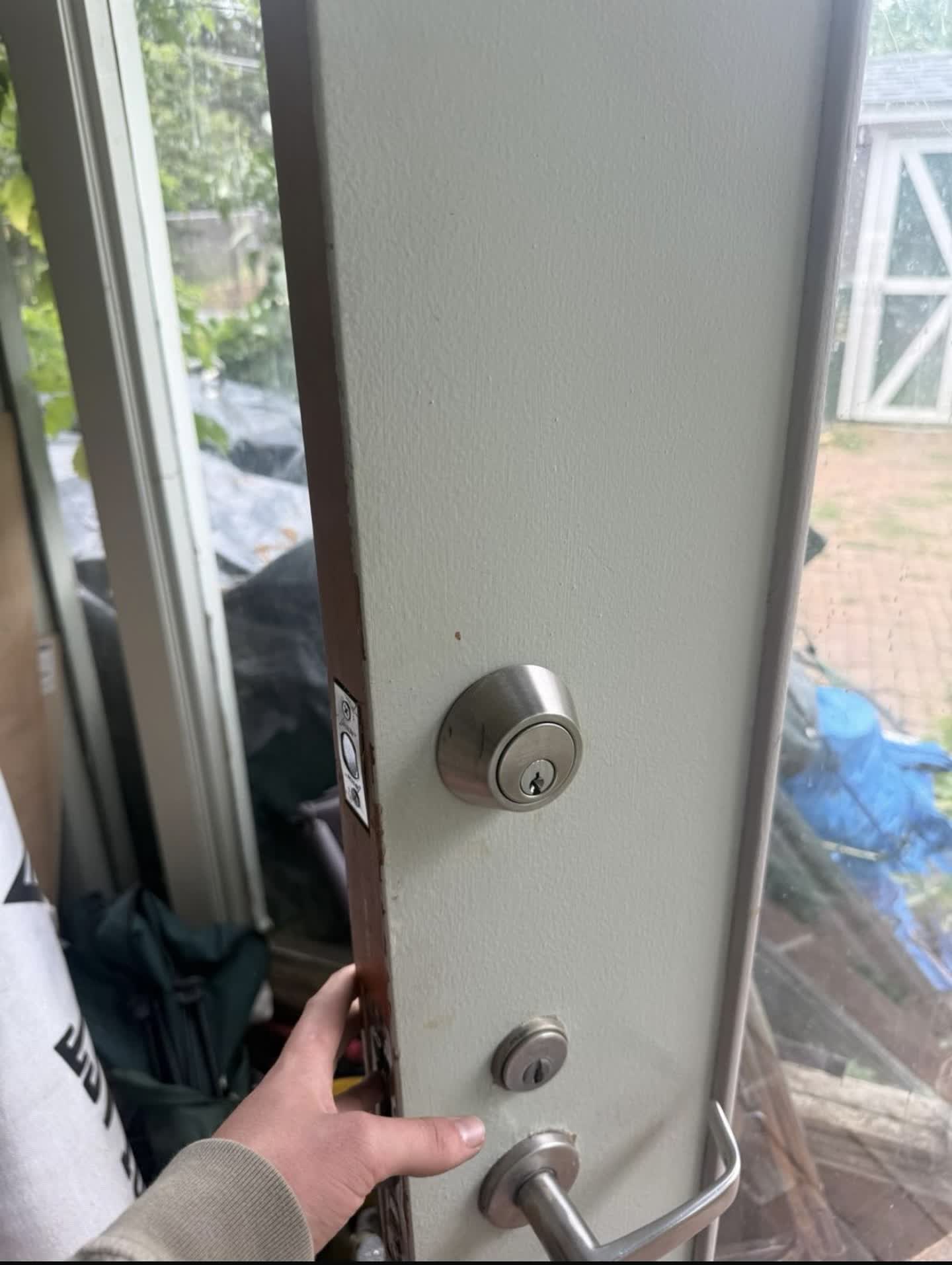 New satin nickel deadbolt installed above the existing lever handle on a home entry door in Lakewood, Colorado