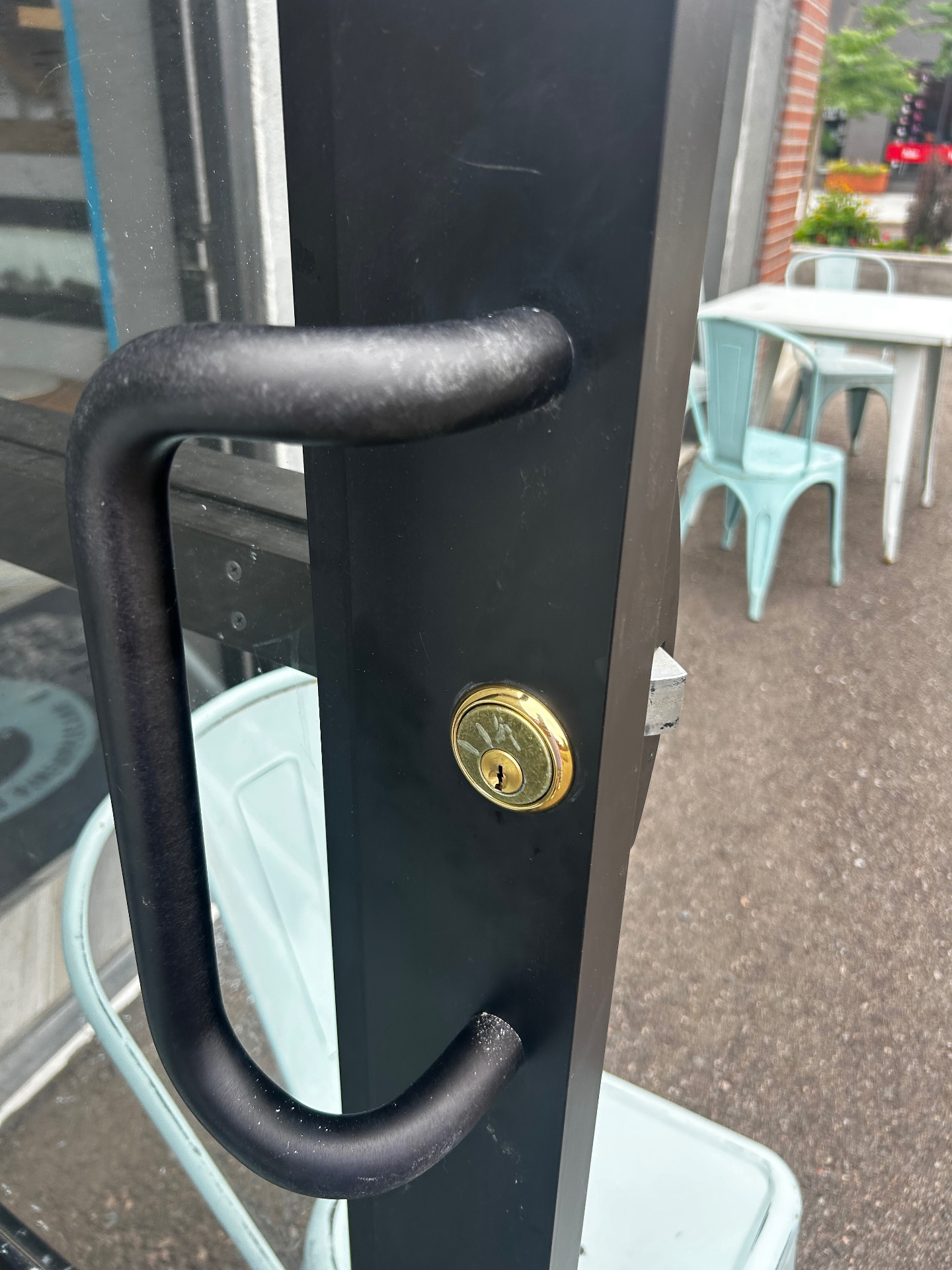 New commercial-grade cylinder installed in a black aluminum storefront door in Denver, Colorado